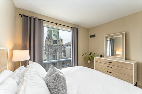 50 WB's furnished apartment showing a bedroom with a bed and a view of a church